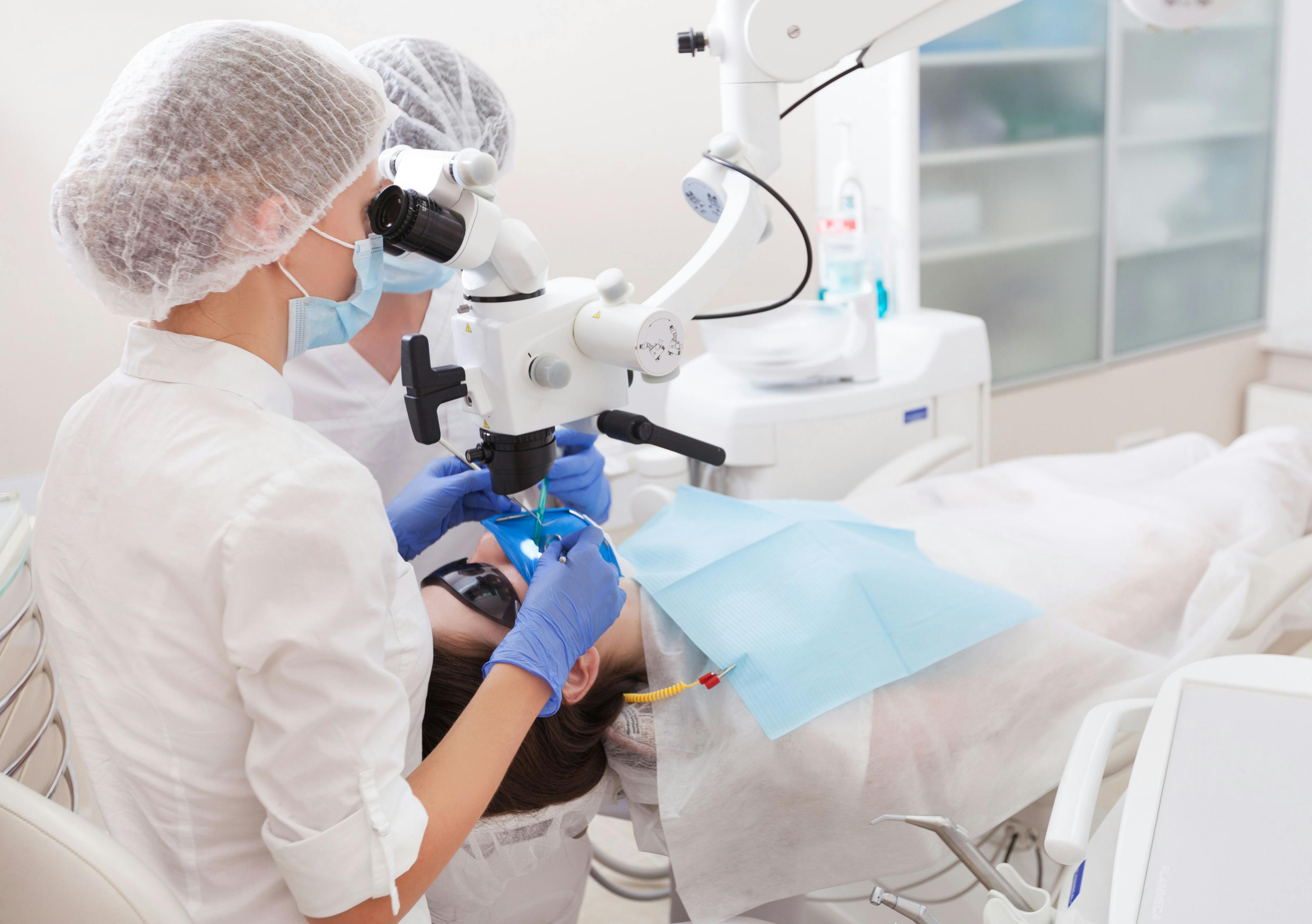 Clinicians perform an endodontic procedure on a patient 