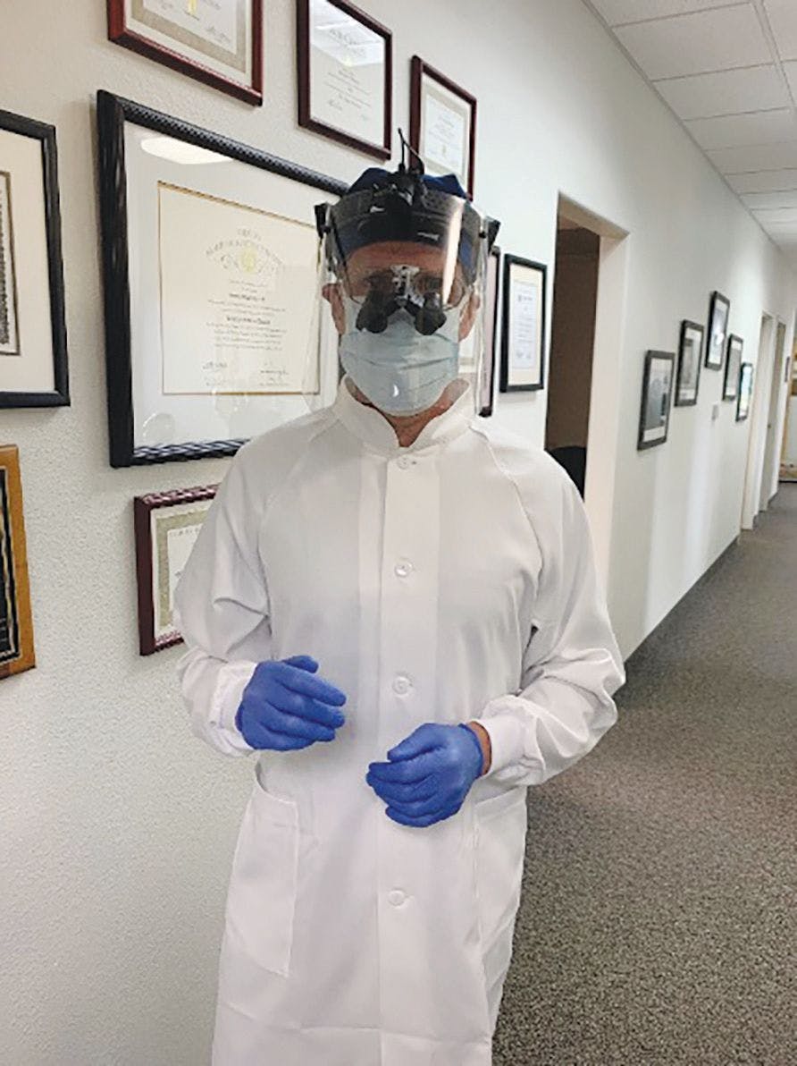 A dentist follows new PPE recommendations,  a result of the COVID-19 pandemic.