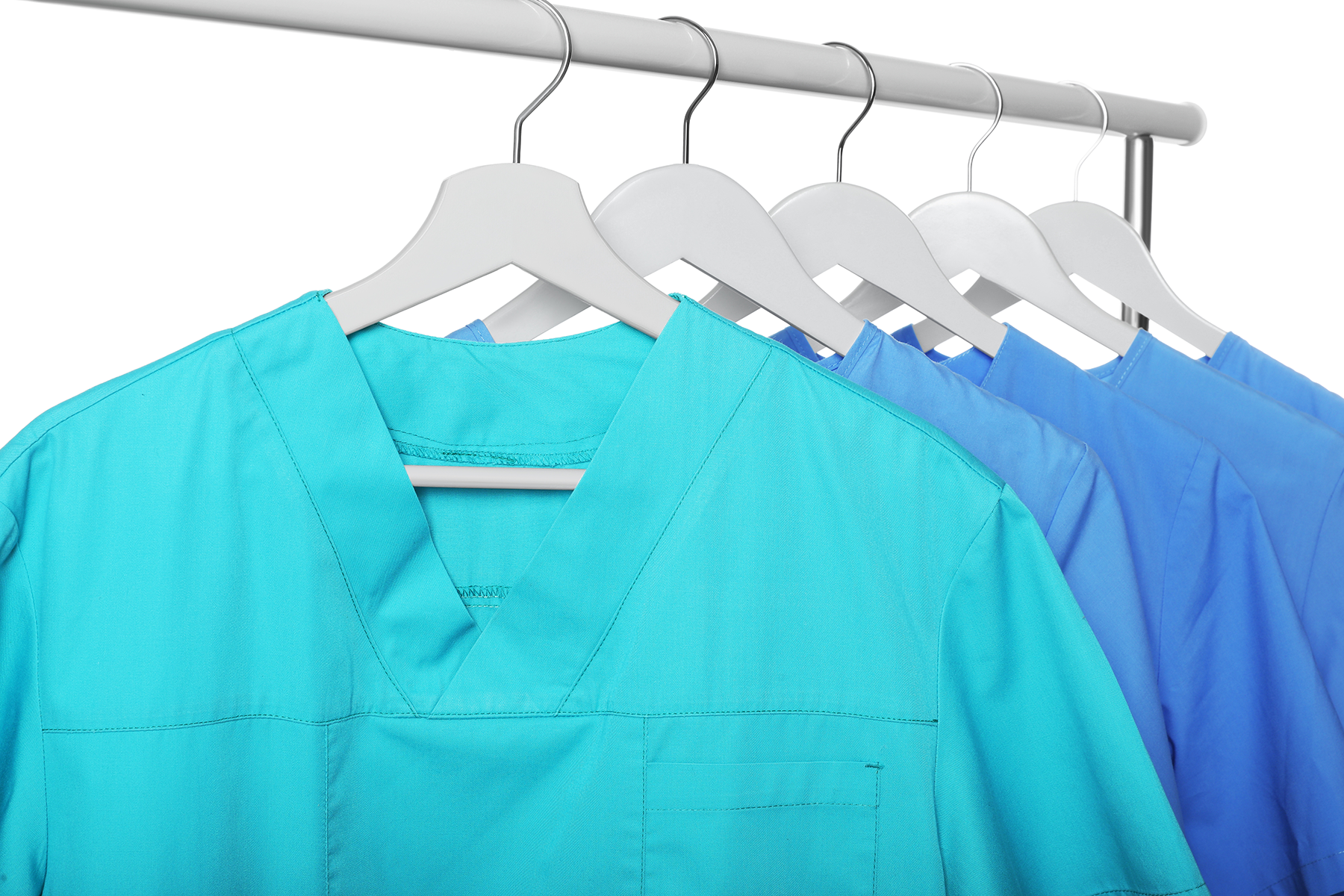 The Role of Modern Scrub Technology in Hygiene and Comfort - Turquoise and light blue medical uniforms on rack against white background | Image Credit: New Africa / stock.adobe.com