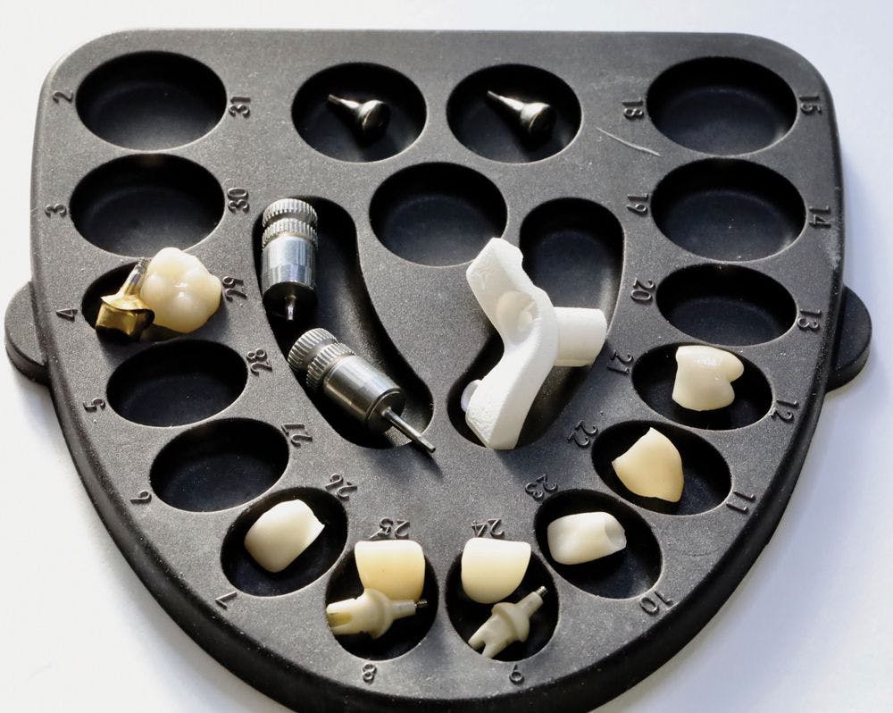 A dental implant case with associated crowns is organized in the LaminateButler for efficient restoration seating.