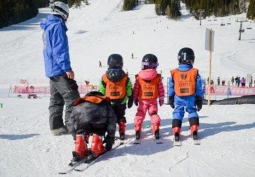 young ski students at the top of a hill