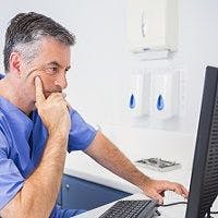 dentist at computer - 5 Things Every Good Dentist Website Should Have