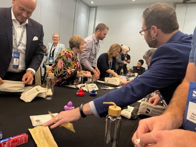 Members of the Dentsply Sirona executive team joined media members to help create oral care packages to donate to TeamSmile Thursday afternoon. Image Credit: © Stan Goff