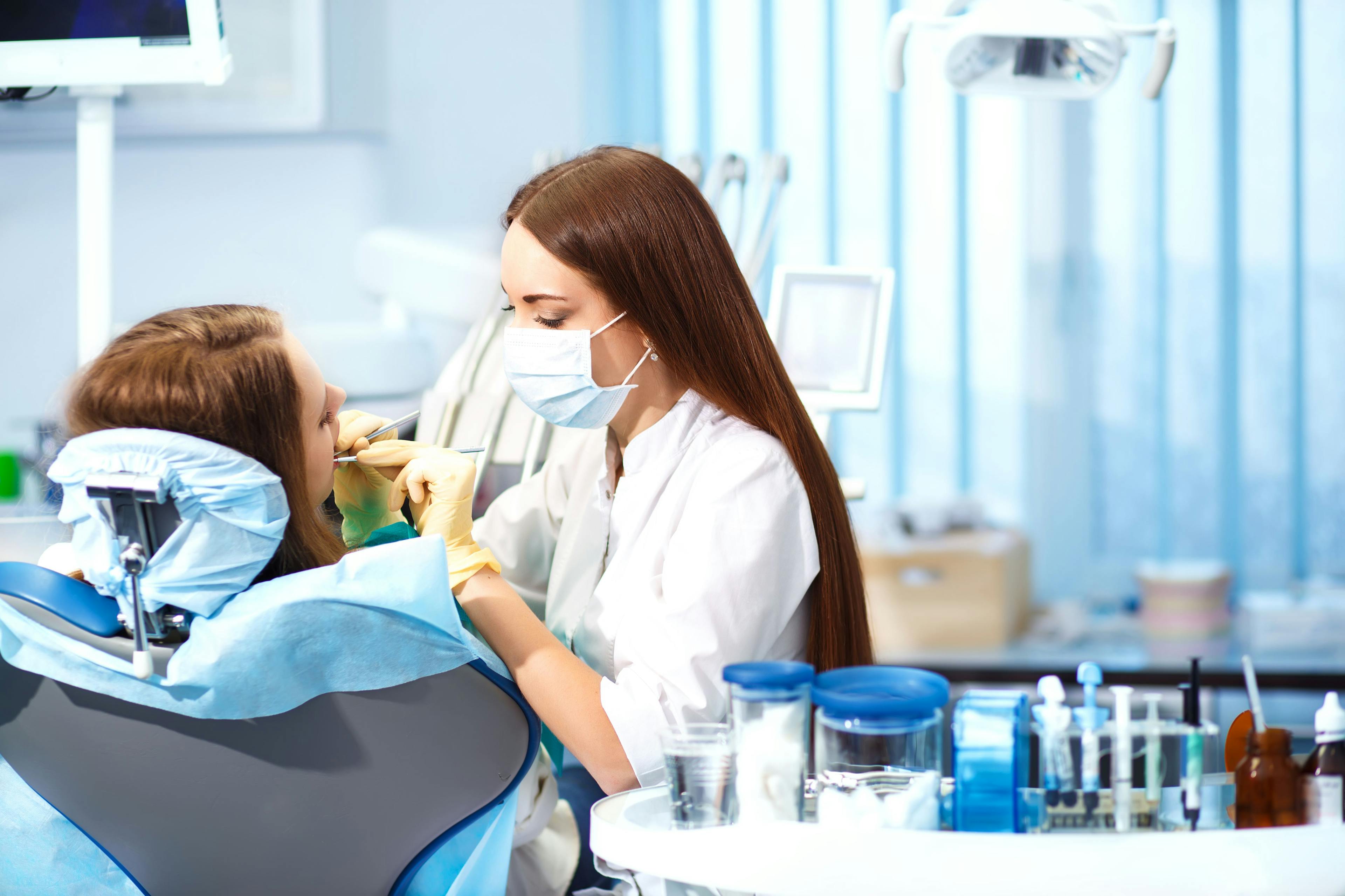 Professional woman dentist doctor working . woman at dental clinic. lady woman at dentist taking care of teeth.Dental care for people. Dentist holding dental device for fixing teeth. | ©maxbelchenko - stock.adobe.com